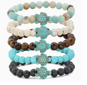 Detail view of five beaded bracelets with turquoise turtles and volcanic stones