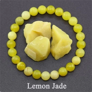 Macro detail of 8mm lemon jade beaded bracelet with raw natural stones on grey surface