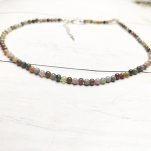 Macro shot of 4mm multi-color tourmaline beads necklace with silver lobster clasp detail