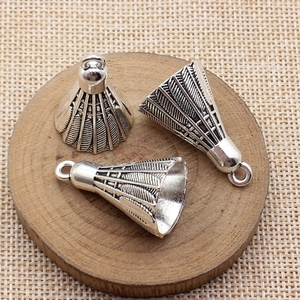 Set of three silver 3D metal shuttlecock pendants for DIY jewelry making on wooden tray