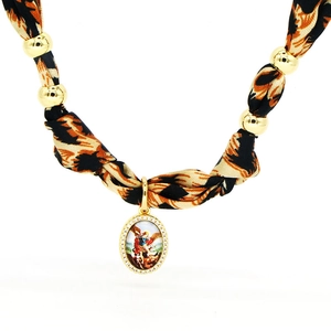 Dettaglio della collana foulard in seta leopardata con perle dorate e ciondolo ovale