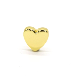 Close-up of heart-shaped gold charm with mirror polish finish and hole for DIY jewelry