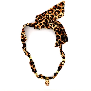 Dettaglio della collana a fiocco leopardato con perle dorate e ciondolo a ritratto ovale