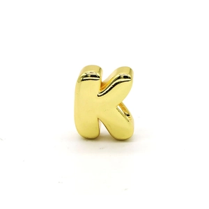 Close-up of a 3D bubble style letter K gold charm with a polished finish for jewelry