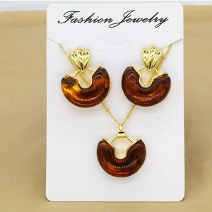 Detail view of amber resin half-moon necklace and earring set on jewelry card
