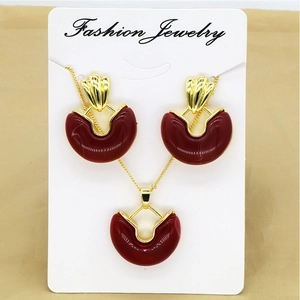 Detail of vintage gold necklace and earring set with deep red resin heart-shaped charms