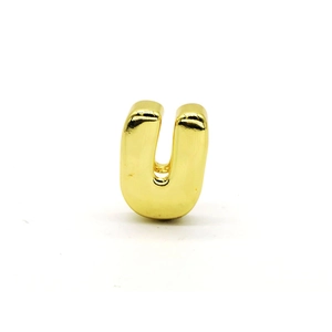 Close-up of polished golden letter U pendant with smooth surface and 3D design