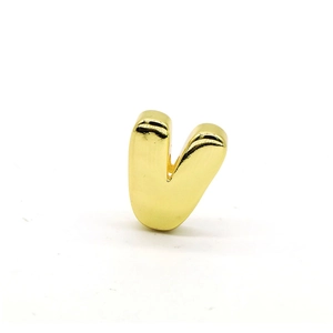 Macro view of 3D gold bubble letter V pendant with glossy metallic finish
