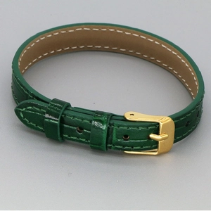 Detail of dark green crocodile pattern leather strap with gold buckle and white stitching