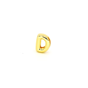 Macro view of gold-plated letter D jewelry bead with high-polished finish and hole