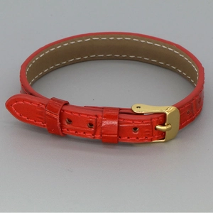 Close-up of red crocodile-pattern leather bracelet with a gold-tone metal buckle closure