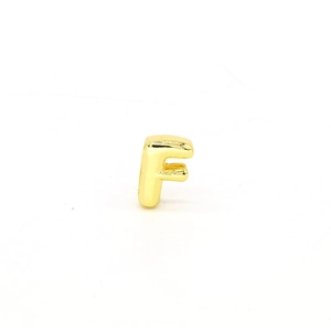 Detailed macro view of a 18K gold plated letter F charm for DIY jewelry bracelets