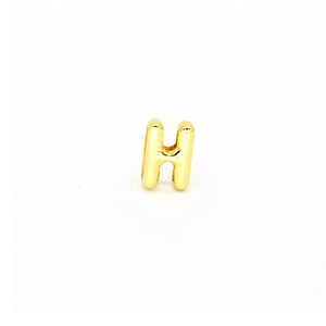 Close-up of polished gold-plated letter H pendant accessory for DIY bracelets
