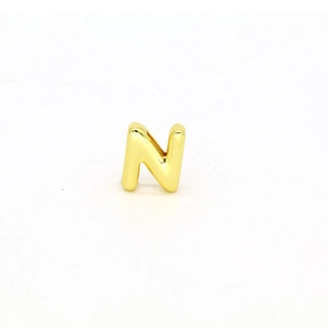 Close-up of polished gold-plated letter N charm for DIY jewelry bracelets and necklaces
