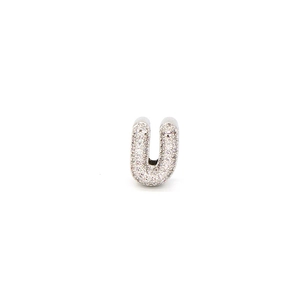 Detail of gold-plated capital letter U charm paved with sparkling white cubic zirconia