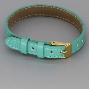 Detail of turquoise leather bracelet with gold buckle and adjustable strap holes