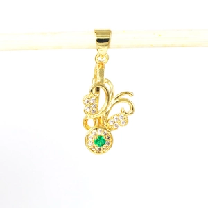 Detailed view of a gold-plated floral pendant with white zircon and a green gemstone