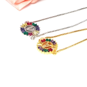 Detail of V-letter pendant with colorful baguette zircons in gold and silver finishes