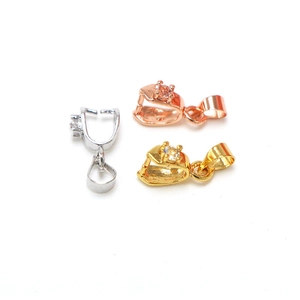 Detailed view of silver, rose gold and gold pinch bails with zircon for jewelry