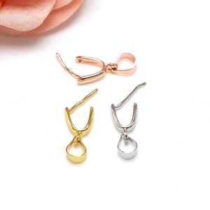 Detailed macro view of pinch bails for jewelry pendants in gold, silver, and rose gold