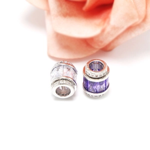 Vue macro de perles barils en argent 925 avec zircons violets et clairs sertis
