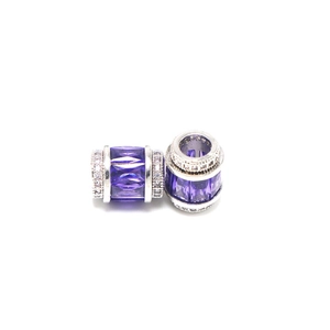 Détail de perle cylindrique en argent avec cristaux baguette violets et serti pavé