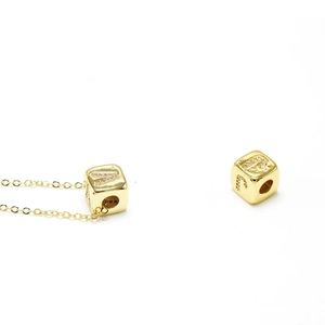 Detail of cubic letter pendants A, J, P in gold finish with micro-inlaid zircons