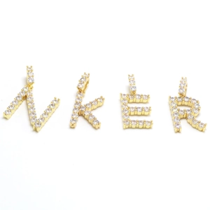 Close-up of gold plated NKER initial charms with micro paved sparkling zircon stones