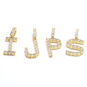 Close-up of gold plated initial pendants I J P S with sparkling crystal micro-pave