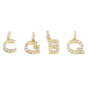 Close-up of gold iced out alphabet pendants C, G, B, Q with sparkling micro pavé zircons