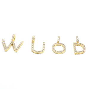 Detailed macro of gold alphabet charms W U O D with sparkling pave-set zircons