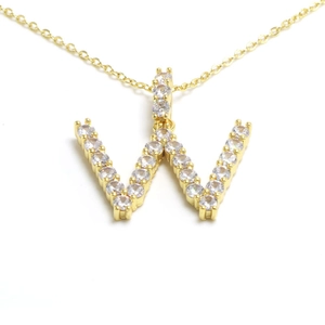 Close-up of gold-plated W letter pendant necklace with sparkling cubic zirconia pavé
