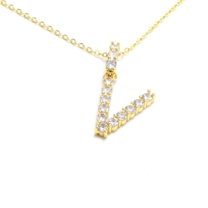 Close-up of gold V-letter pendant with pavé cubic zirconia on minimalist chain