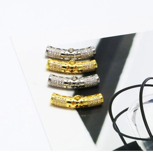 Macro detail of micro-pave zircon curved tube connectors in gold and silver for DIY jewelry