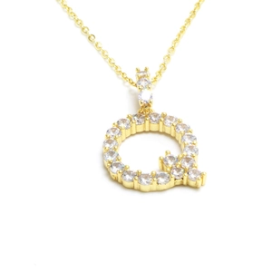 Macro detail of gold letter Q pendant featuring sparkling white pave-set zircons on a link chain
