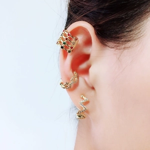 Detail of three gold ear cuffs featuring colorful zircons and lightning design