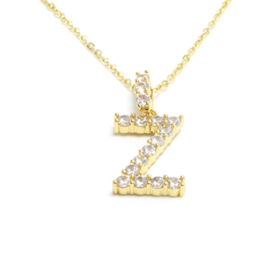 Macro shot of gold letter Z pendant encrusted with clear crystals on a delicate chain