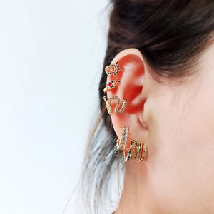 Close-up of gold animal ear cuff set with multi-colored zircons on model ear