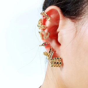 Close-up of gold-plated ear cuff set featuring snake and butterfly designs with colored zircon