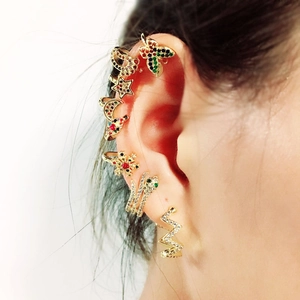 Detailed view of gold earrings set featuring stars, moon and butterfly with zircons