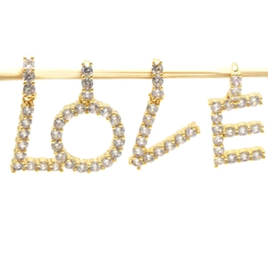 Golden alphabet L-O-V-E pendants with pavé crystals on a wooden display stand