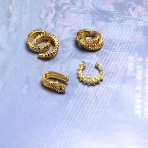 Detail of four gold-plated ear cuffs featuring colorful cubic zirconia and snake design