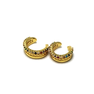 Detailed macro view of gold-colored C-shaped ear cuffs with vibrant multi-color rhinestones