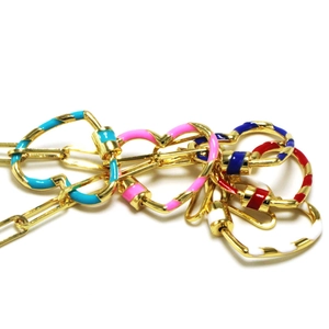 Makroaufnahme von bunten Emaille-Herz-Anhängern mit goldenen Spiralverschlüssen