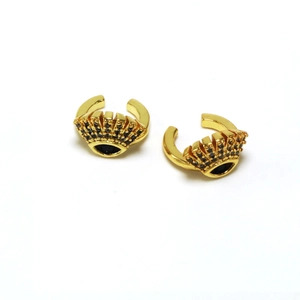 Detail of gold eye-shaped ear cuff with black zircon stones and crown detail