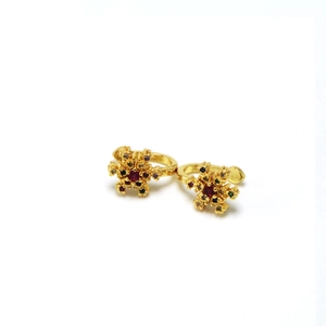 Detailed view of golden snowflake earrings inlaid with vibrant multicolor gemstones