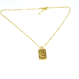 Detalle del collar con colgante dorado con motivos de luna y estrella e incrustación de cristal