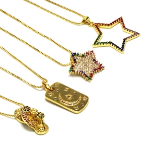 Detalle de collares dorados con colgantes de estrella, luna y chanclas creativas con circonitas