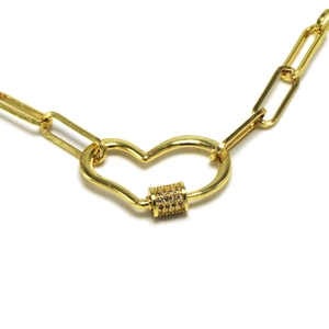 Detail of gold paperclip chain necklace featuring a heart carabiner with micro zircons