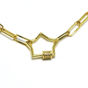 Close-up of gold chain necklace with star clasp and sparkling zircon paved cylinder